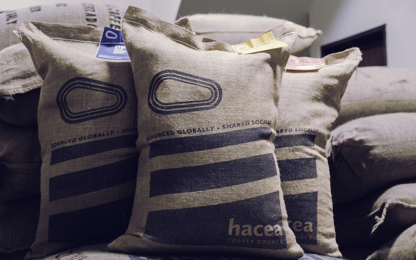 Hacea 20kg bags stacked up in a coffee warehouse.