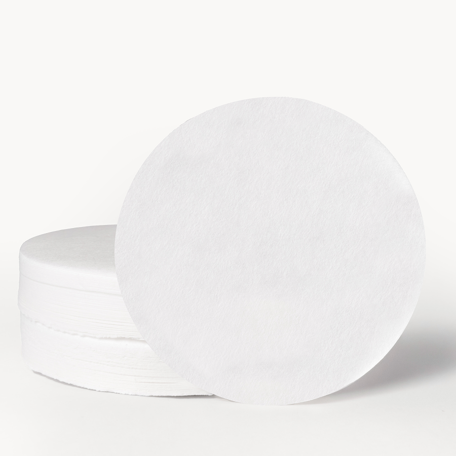 Stack of white paper AeroPress filters on a white background.