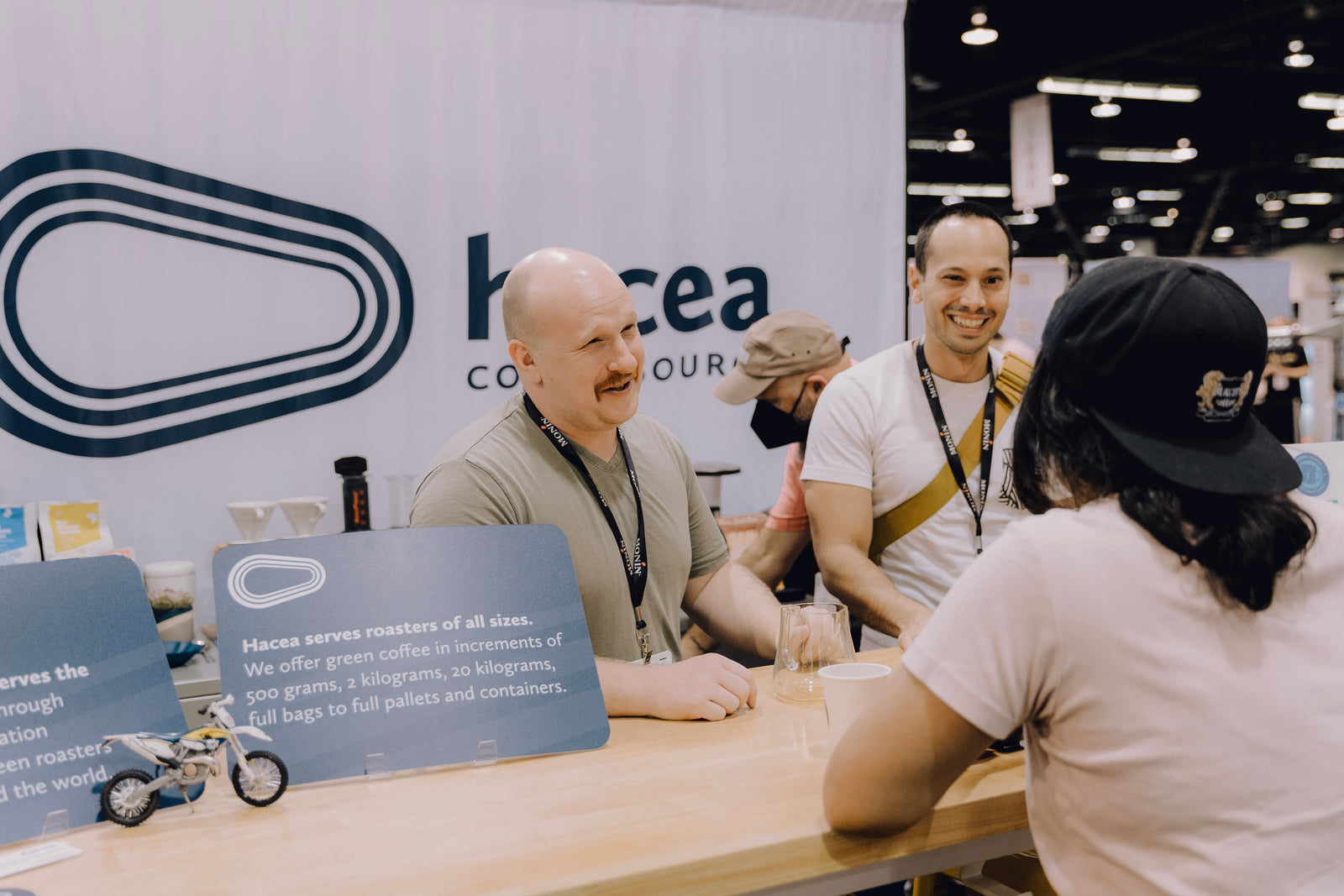 Man connecting with coffee roasters over a countertop.