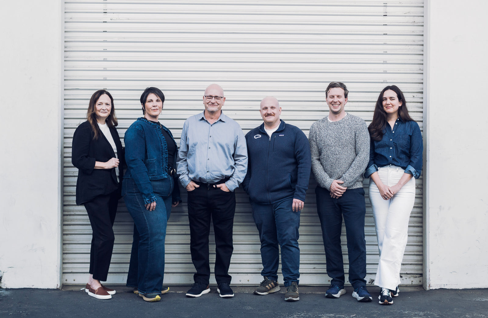 Group of six people from the Hacea team standing in front of a warehouse door.