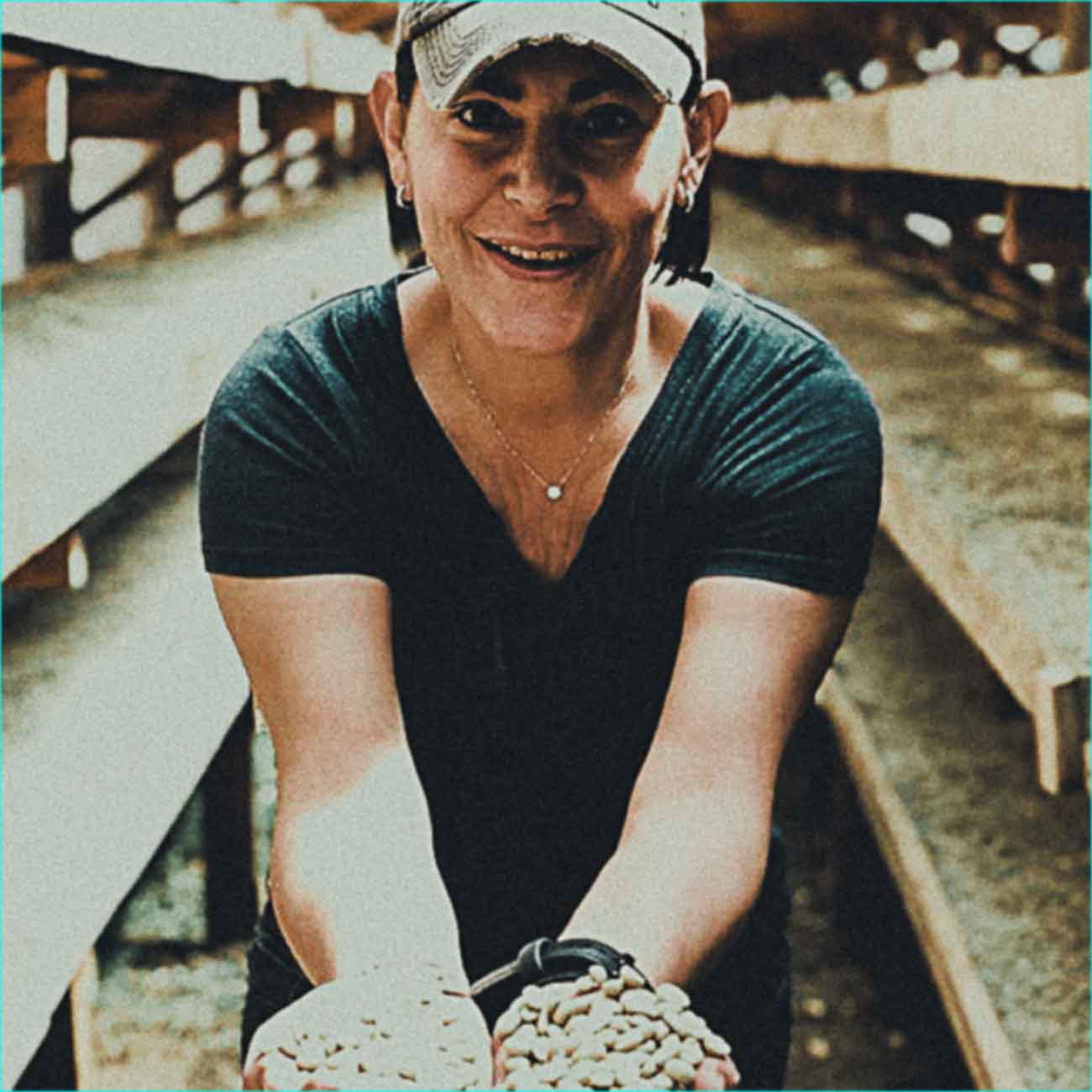 Staff holding drying coffee parchment in their hands.