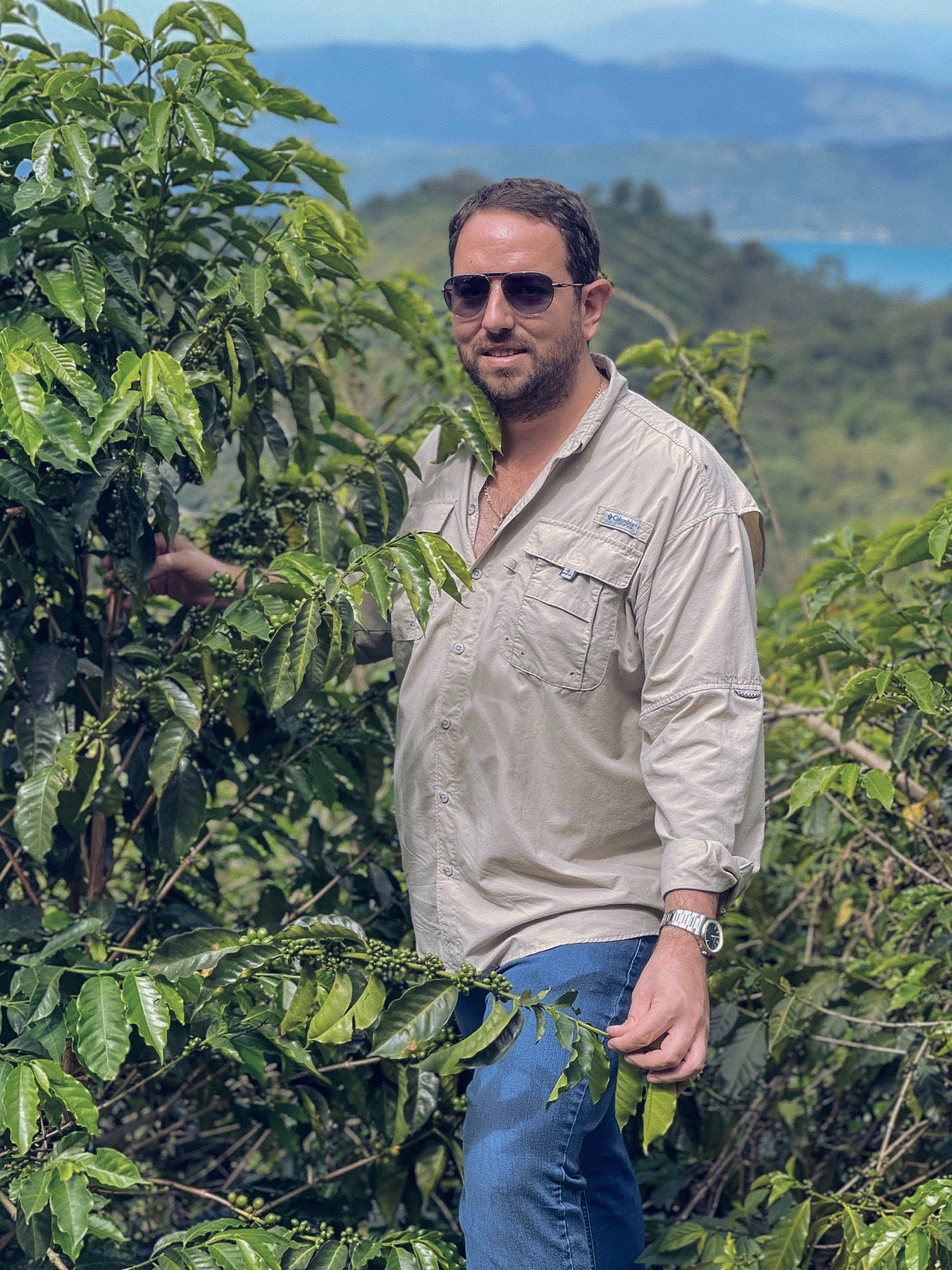 Rafael Silva at Finca El Ángel standing near a coffee plant in El Salvador.